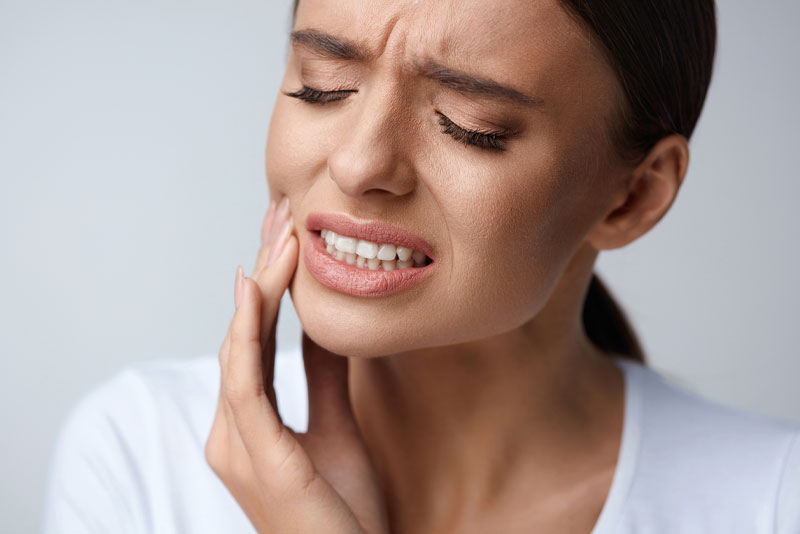 a dental patient in need of a tooth extraction and dental implant experiencing pain.