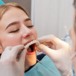a dental patient improving the look and function of her smile with a full arch prosthesis during her full mouth dental implant procedure.