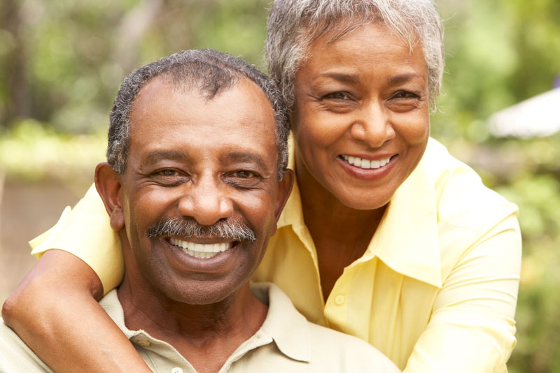an older couple outside smiling because their gum disease was treated with ozone therapy.