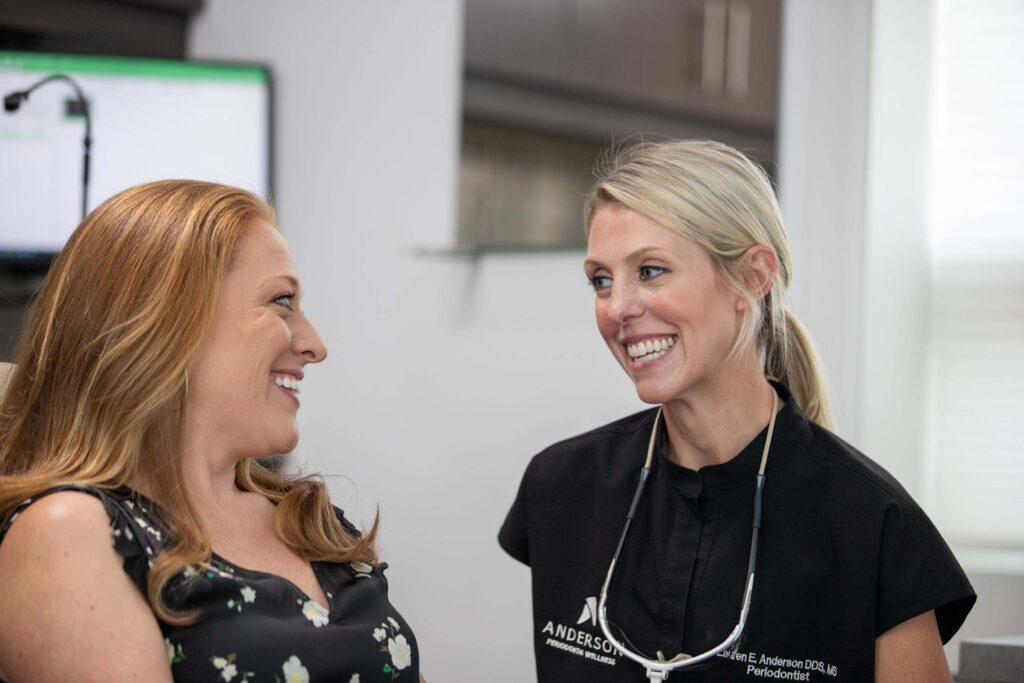 Dr. Anderson smiling with a patient after her gum disease treatment.