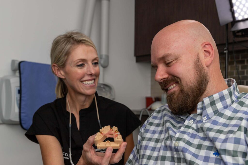 Dr. Anderson showing a patient a full mouth dental implant model.